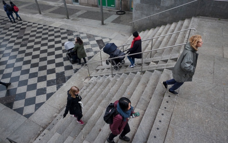 People walking in different directions in a staircase.